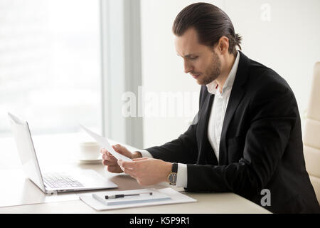 Serious businessman in the office reading important financial do Stock Photo