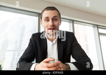 Portrait of young businessman looking in camera and talking. Stock Photo