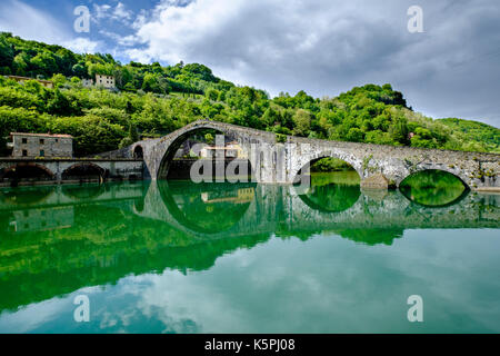 The bridge Ponte della Maddalena, Bridge of Mary Magdalene, also Ponte del Diavolo or Bridge of the devil, is crossing the river Serchio Stock Photo