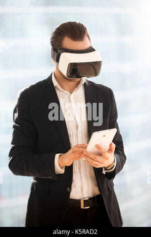 Businessman in vr glasses working on electronic tablet. Stock Photo