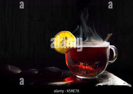 A beautiful, hot, black tea from India on a black flone made of stone. Useful, very strong and thick drink for vivacity Stock Photo