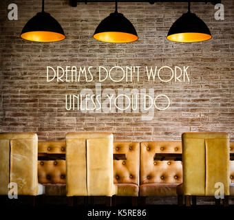 Dreams Dont Work Unless You Do motivational message written on vintage brick wall Stock Photo