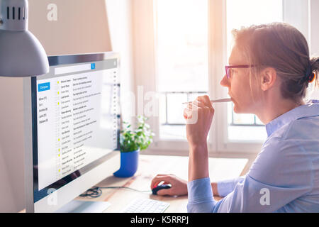 Female business person reading email on computer screen at work on internet Stock Photo