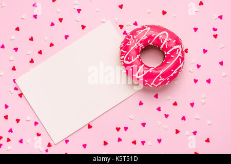 Donuts with icing on pastel pink background with copyspace. Sweet donuts. Stock Photo