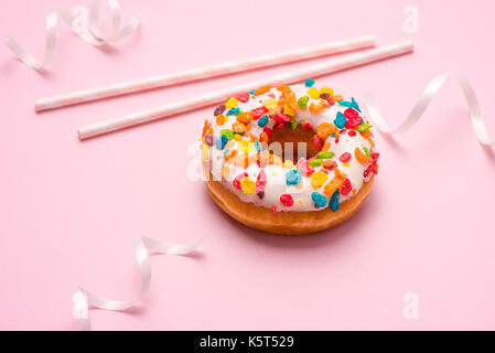 Delicious donuts for birthday on pastel pink background. Stock Photo