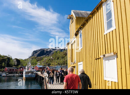 Tourists visiting historic fishing village harbour in Nusfjord, Flakstadøya Island, Lofoten Islands, Nordland, Norway, Scandinavia Stock Photo