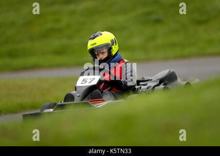Young boys learn to drive karts on a track during a Junior Karting course at Thruxton racing circuit in Thruxton Hampshire, England Stock Photo