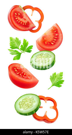 Isolated slices of vegetables. Falling cut cucumber, tomato and bell pepper (salad ingredients)  isolated on white background with clipping path Stock Photo