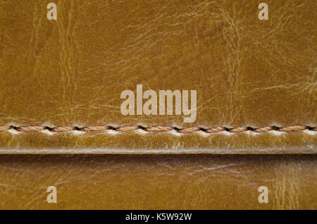 Texture of brown leather with stitches. Element of leather clothing close-up. Seams on leather products Stock Photo