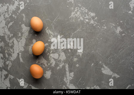 Three eggs on a concrete table. Top View. Stock Photo