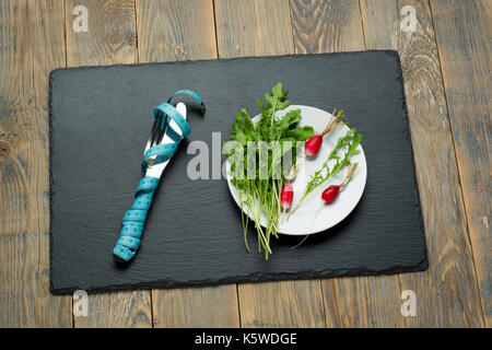 Fresh salad and measuring tape on wooden background Stock Photo