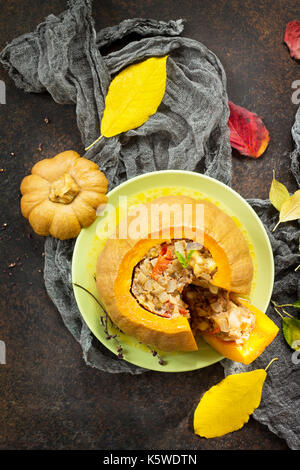 Baked pumpkin stuffed with Turkey, tomatoes, onions and cheese. The concept of food on thanksgiving. Stock Photo