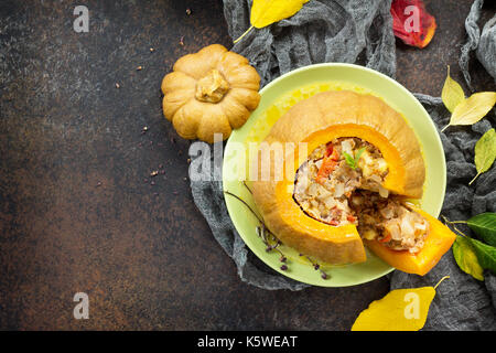 Baked pumpkin stuffed with Turkey, tomatoes, onions and cheese. The concept of food on thanksgiving. Stock Photo