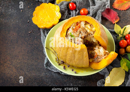Baked pumpkin stuffed with Turkey, tomatoes, onions and cheese. The concept of food on thanksgiving. Stock Photo