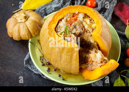Baked pumpkin stuffed with Turkey, tomatoes, onions and cheese. The concept of food on thanksgiving. Stock Photo