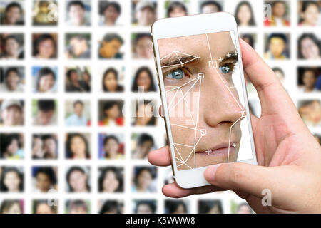 Machine learning systems technology , accurate facial recognition biometric technology and artificial intelligence concept. Hand using mobile phone an Stock Photo