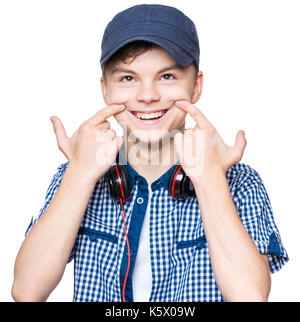 Silly boy making grimace. Child with wry smile, isolated on white background. Emotional portrait of caucasian teenager looking at up. Stock Photo