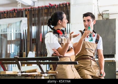 Carpenters having break from their work in wood workshop Stock Photo