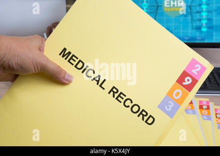 Yellow medical record folder in someone hand. Stock Photo