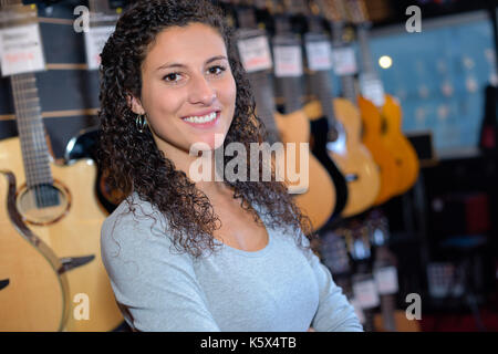 portrait of woman seller in guitar shop Stock Photo