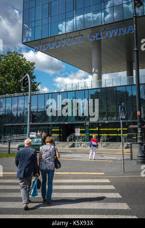 Bydgoszcz, Poland -  August 2017 : Couple crossing the road in front of the newly refurbrished Bydgoszcz Glowna train station building Stock Photo