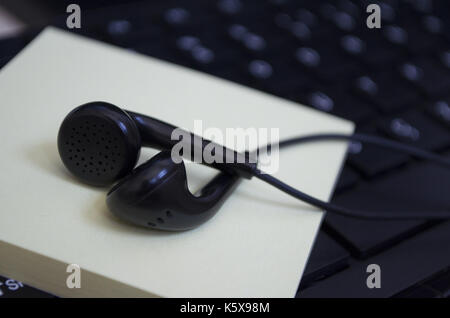 headphone over laptop keybaord Stock Photo