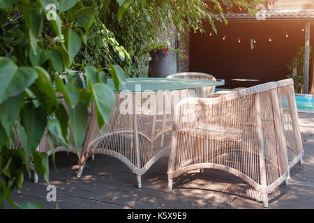 Wicker armchairs and table, modern garden furniture. Cozy space for relax in the garden. Stock Photo