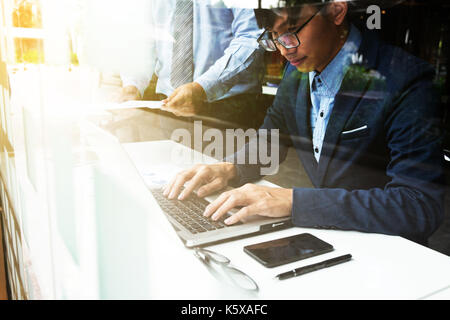 Team work process. young business managers crew working with new startup financial project. labtop on wood table, typing keyboard, texting message, an Stock Photo