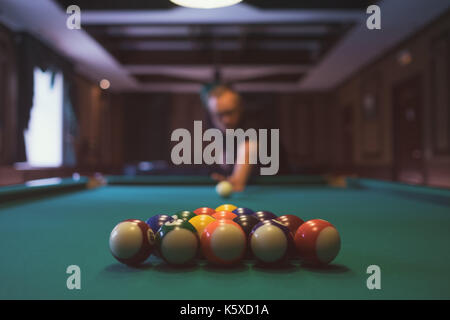 Young man playing billiard indoors. Spending free time on gambling Stock Photo