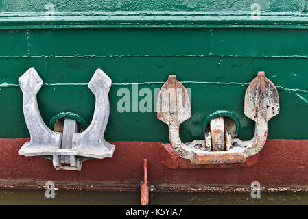 Two anchors on red and green hull just above the water line Stock Photo