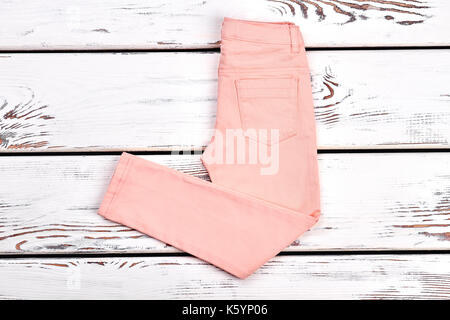 Teen girls modern summer trousers. Female slim peach color pants on white  wooden background, copy space. Woman summer fashion outfit Stock Photo -  Alamy