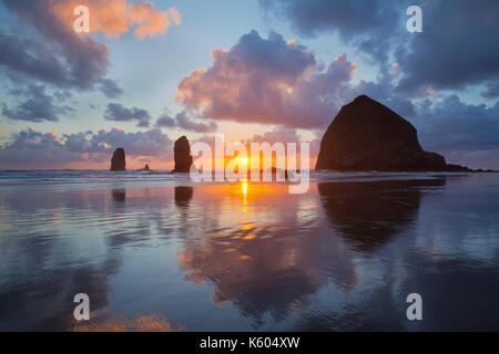 Sunset over Haystack Rock and Cannon Beach along the Oregon Coast. USA Stock Photo