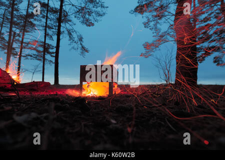 Burning firewood in the barbecue against the sky. Stock Photo