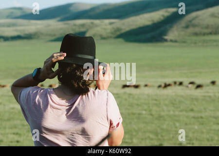Photographer holds a camera and photographs. Stock Photo