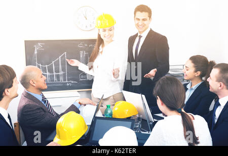 Team of happy engineers discussing new project and smiling indoors Stock Photo