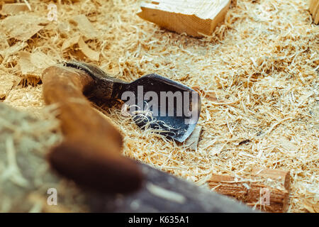 Rusty tip of sharp ax lies on edging boards Stock Photo