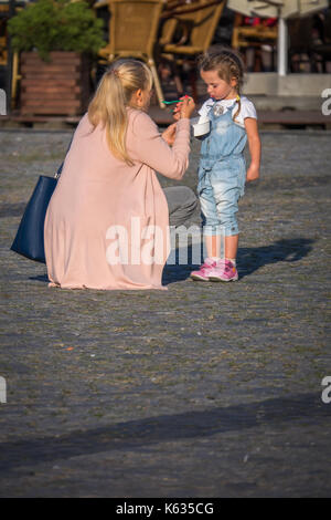 Bydgoszcz, Poland -  August 2017 :  Mother and daughter eating ice cream on the street in the Old Town square Stock Photo