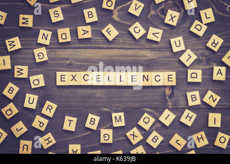Excellence word wood block on table for business concept. Stock Photo