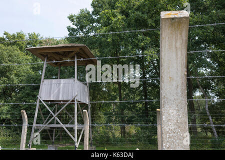 Fence with barbed wire and a watchtower at former concentration camp 'kamp Vught' in the Netherlands Stock Photo