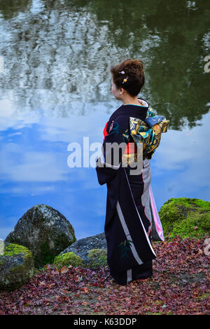 A Japanese woman in traditional dress (kimono) standing at the autumn park in Nara, Kansai, Japan. Stock Photo