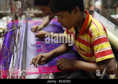 Artisan weaving Jamdani saree on the traditional handloom at Rupganj. Jamdani is a superfine handloom fabric, which has evolved through generations of Stock Photo