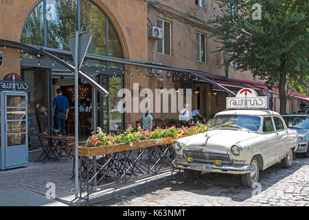 Street in Yerevan, Armenia, with restaurants and cafes. Vintage car outside a reataurant used for advertising. Stock Photo