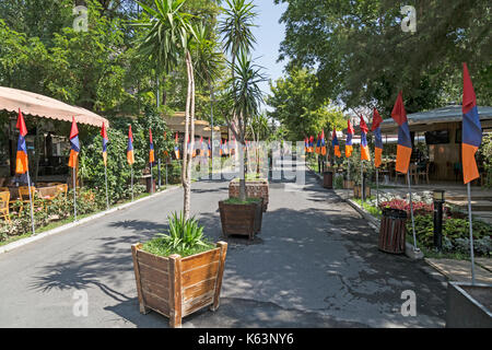 Restaurants and cafes in a street in the centre of Yerevan, capital city of Armenia. Armenian flags decorate the street. Stock Photo