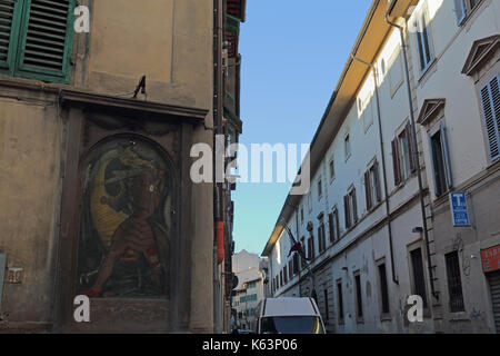 Painted mural of knight fighting dragon on wall in street. Florence, Italy. Stock Photo