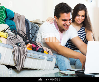 Smiling young couple preparing for honeymoon and making planning list Stock Photo