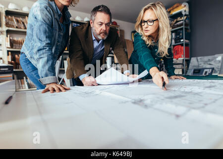 Team of architects working on construction drawing. business people working together on blueprint in office. Stock Photo
