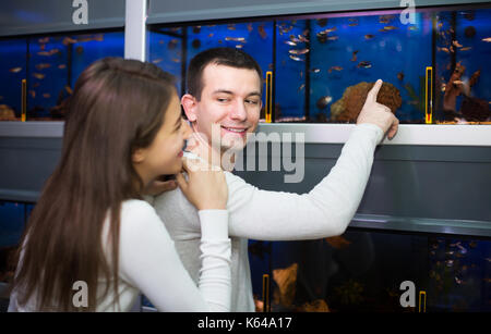 Man with positive girlfriend choosing aquarium fish in aquarium Stock Photo