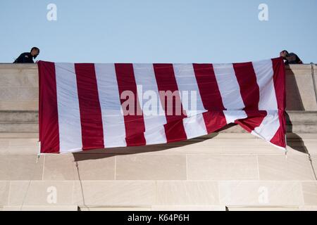 Arlington, United States Of America. 11th Sep, 2017. A large American flag is unfurled over the west side of the Pentagon at sunrise in preparation for an the ceremony commemorating the anniversary of the 9/11 terrorist attacks at the Pentagon September 11, 2017 in Arlington, Virginia. The aircraft impacted the building where the flag is unfurled. Credit: Planetpix/Alamy Live News Stock Photo