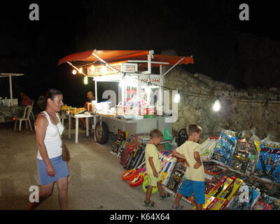 children and mother looking at toys on staff at panagiri celebration in Xanthates, Corfu, Greece Stock Photo