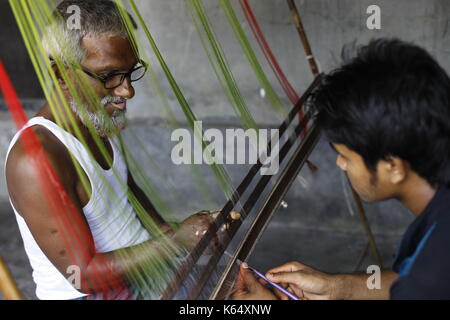 Artisan weaving Jamdani saree on the traditional handloom at Rupganj. Jamdani is a superfine handloom fabric, which has evolved through generations of Stock Photo